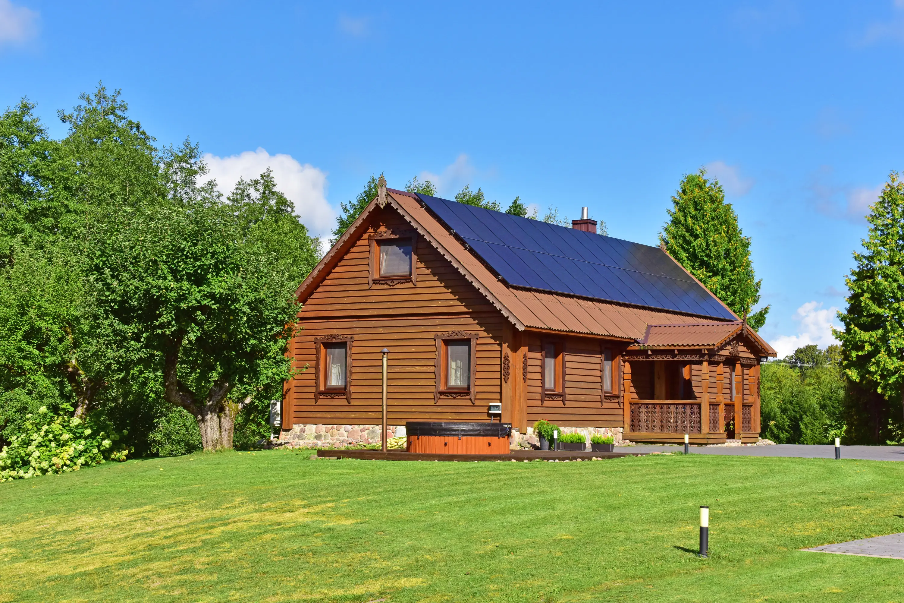 Ant Kalnuko wooden house surrounded by green trees